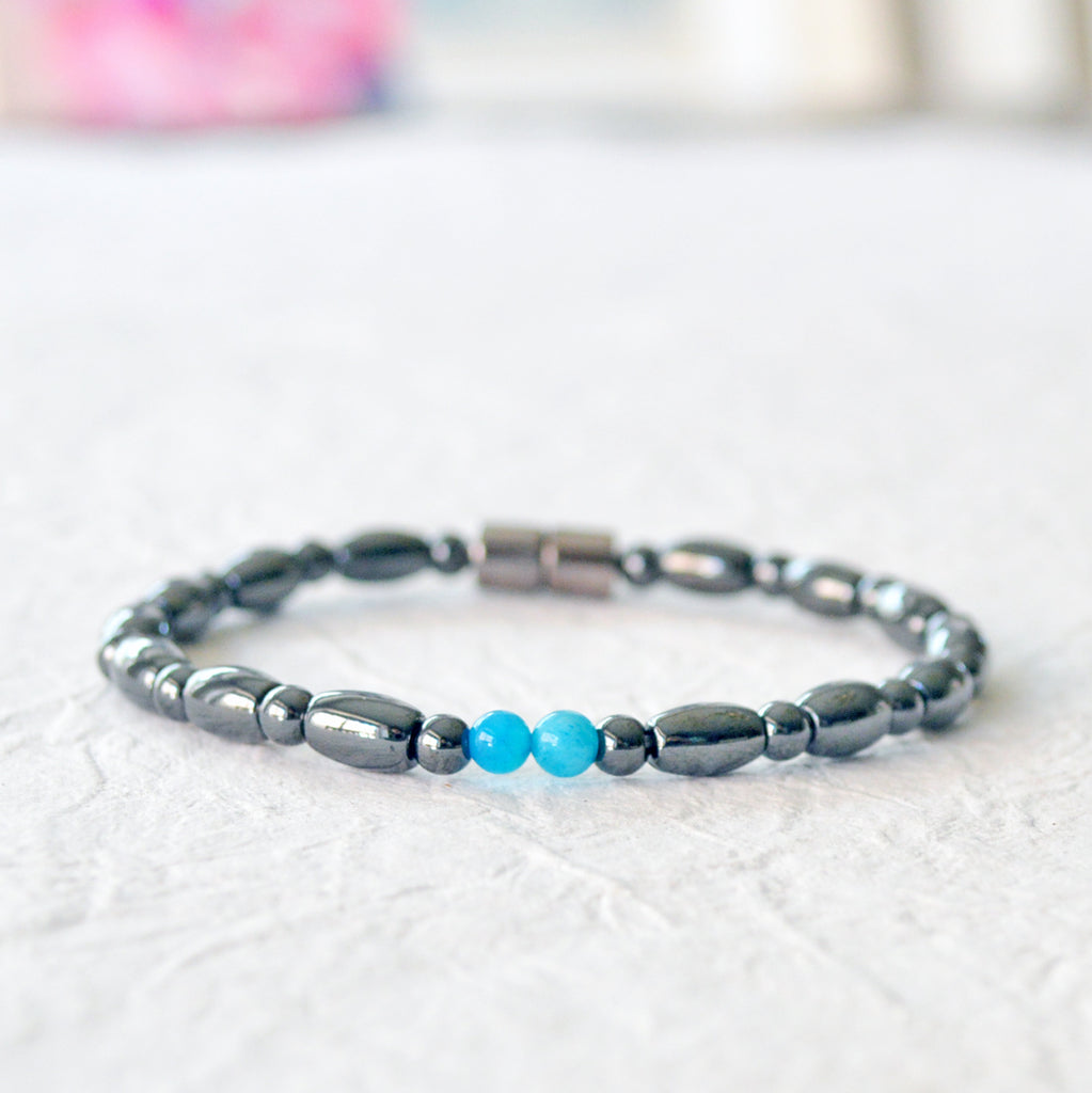 Magnetic bracelet for women handcrafted with black hematite magnetic beads with two blue magnesite beads in the center. Bracelet secured with a strong magnetic clasp.