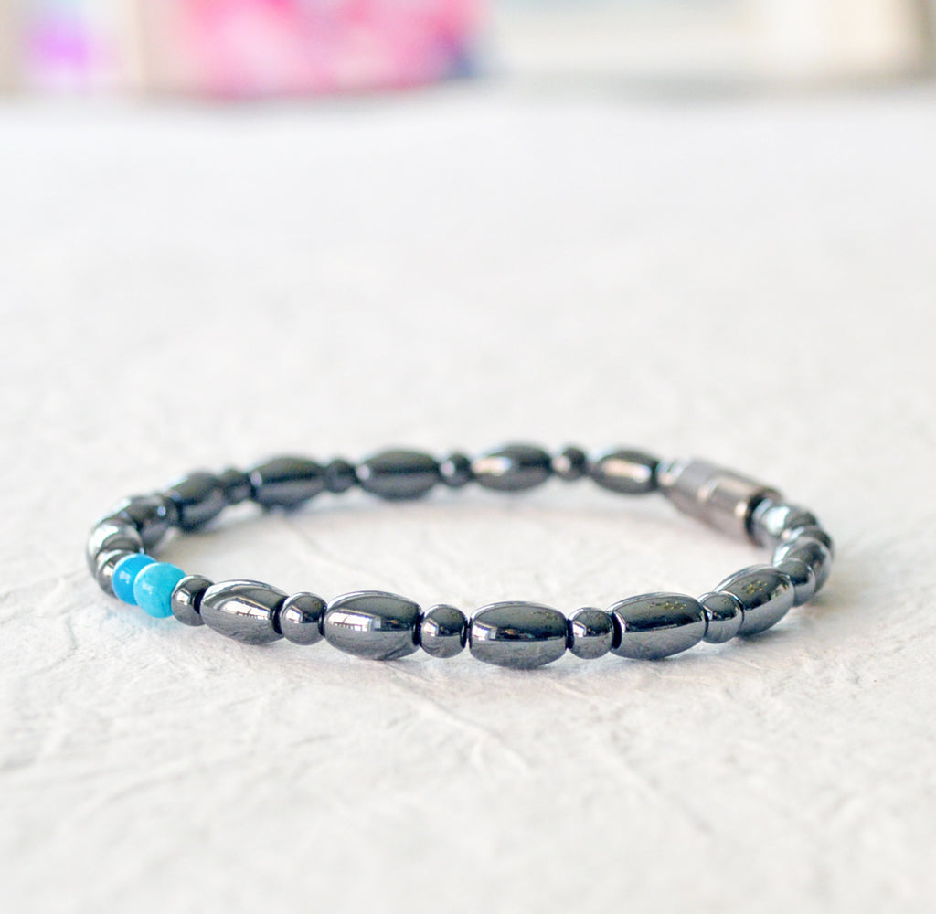 Magnetic bracelet for women handcrafted with black hematite magnetic beads with two blue magnesite beads in the center. Bracelet secured with a strong magnetic clasp.