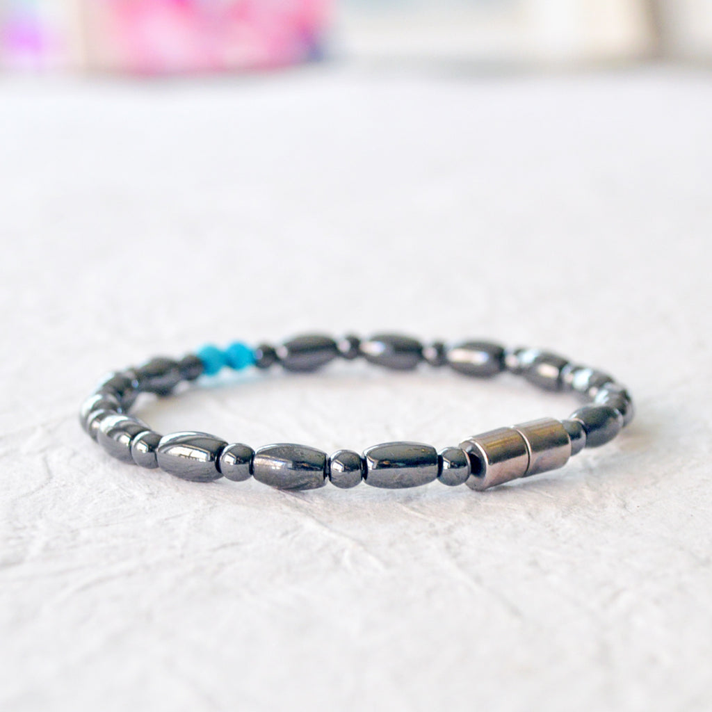 Magnetic bracelet for women handcrafted with black hematite magnetic beads with two blue magnesite beads in the center. Bracelet secured with a strong magnetic clasp.