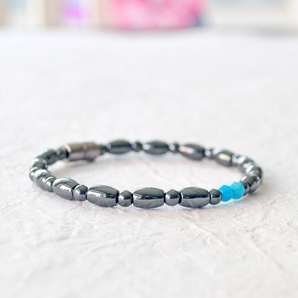 Magnetic bracelet for women handcrafted with black hematite magnetic beads with two blue magnesite beads in the center. Bracelet secured with a strong magnetic clasp.