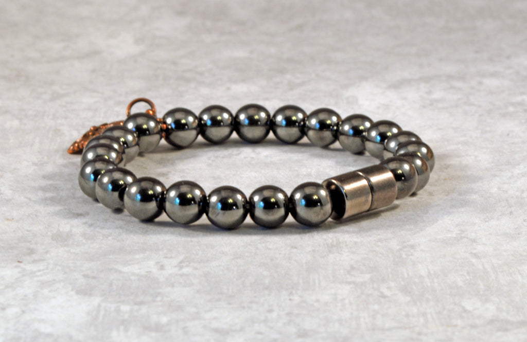 Magnetic therapy bracelet crafted with high power magnetic hematite beads with an antique flower charm in the center. Secured with a strong and easy-to-use magnetic clasp.