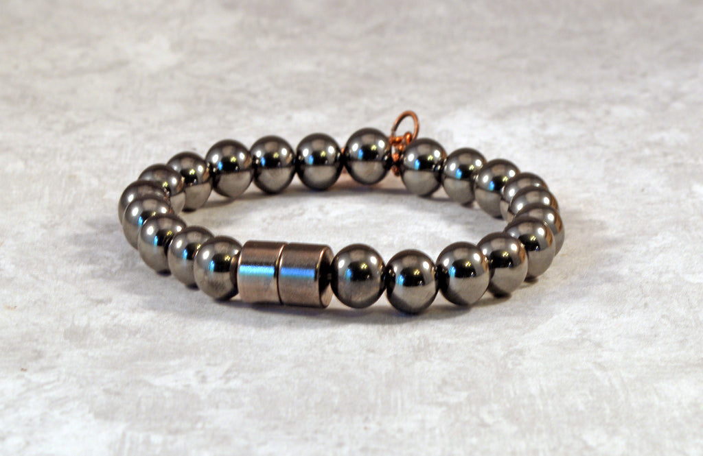 Magnetic therapy bracelet crafted with high power magnetic hematite beads with an antique flower charm in the center. Secured with a strong and easy-to-use magnetic clasp.