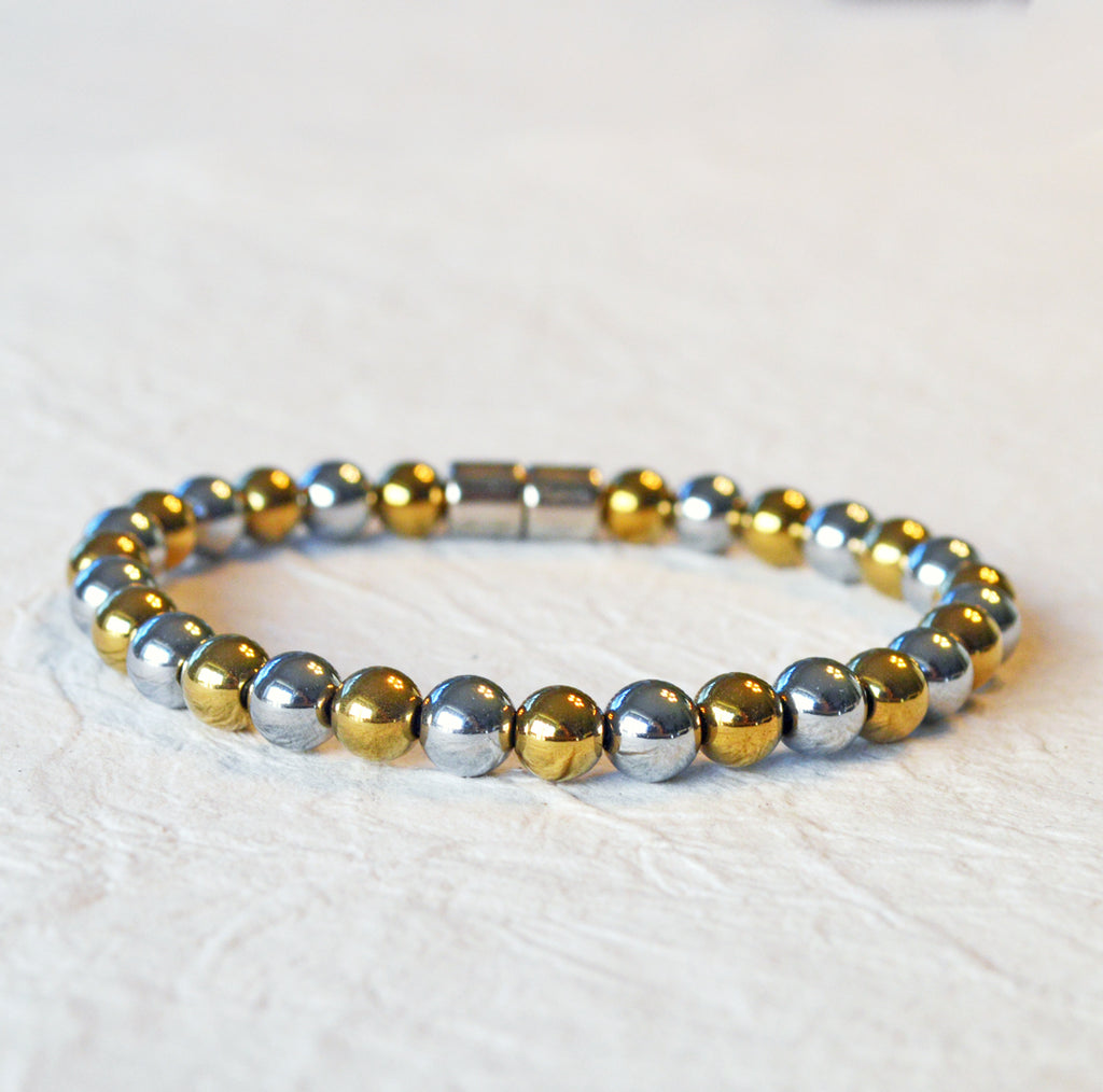 Magnetic bracelet handcrafted with alternating gold and silver metallic magnetic beads. Secured with a strong and easy-to-use magnetic clasp.