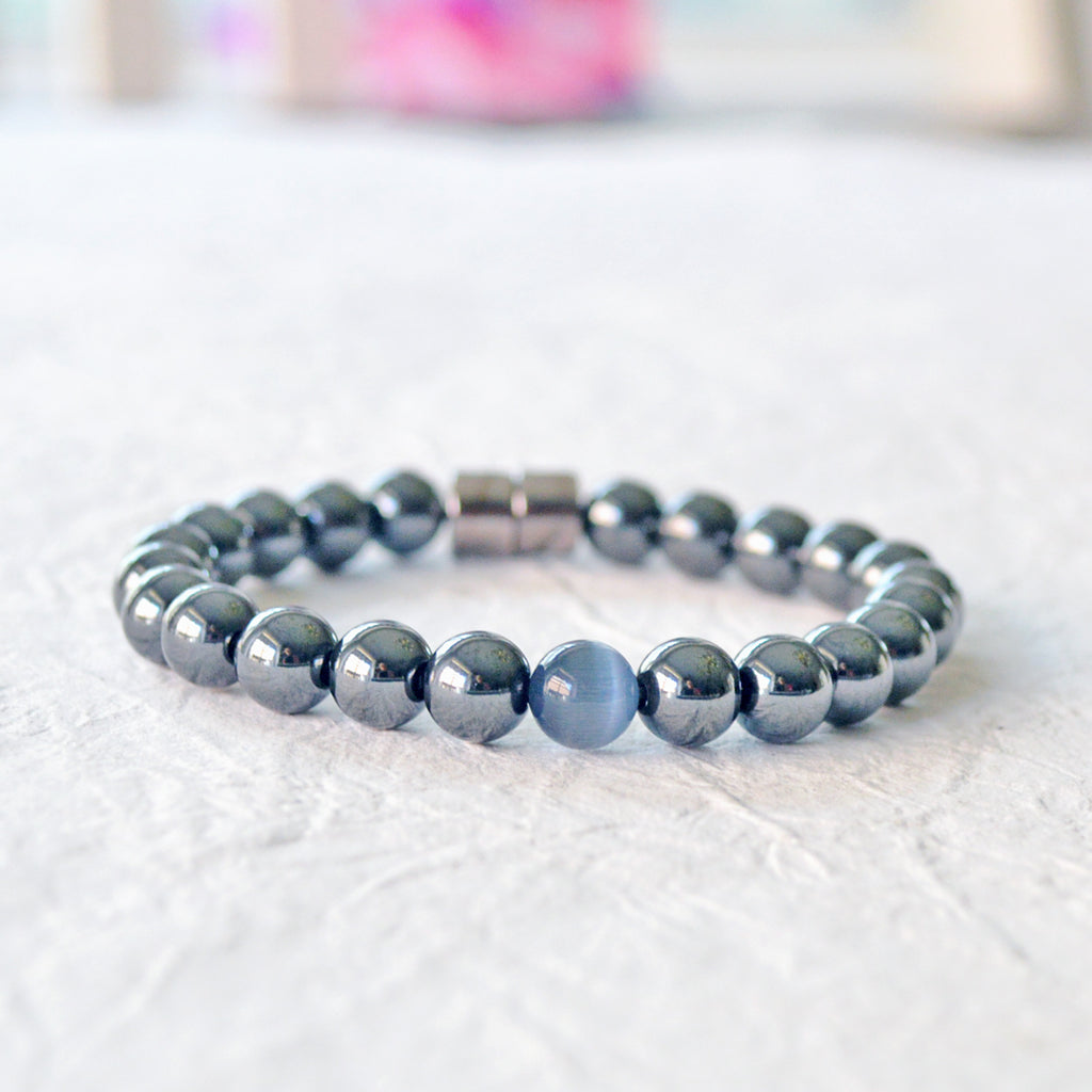 Black Hematite Magnetic bracelet handcrafted with powerful hematite magnetic beads with a grey cat's eye bead in the center. Secured with a strong and easy-to-use magnetic clasp.