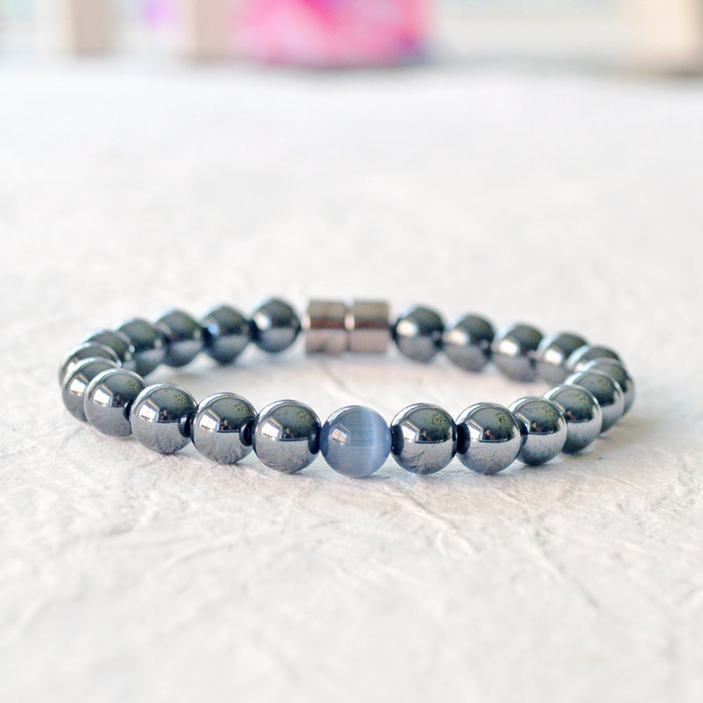 Black Hematite Magnetic bracelet handcrafted with powerful hematite magnetic beads with a grey cat's eye bead in the center. Secured with a strong and easy-to-use magnetic clasp.