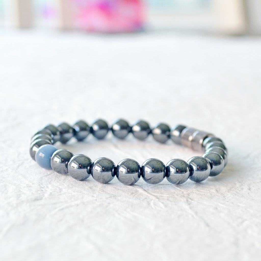 Black Hematite Magnetic bracelet handcrafted with powerful hematite magnetic beads with a grey cat's eye bead in the center. Secured with a strong and easy-to-use magnetic clasp.