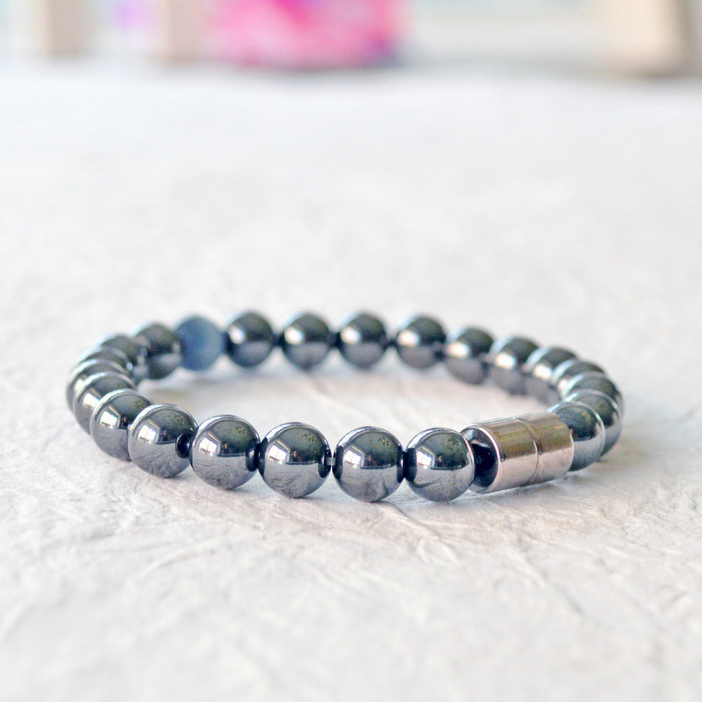 Black Hematite Magnetic bracelet handcrafted with powerful hematite magnetic beads with a grey cat's eye bead in the center. Secured with a strong and easy-to-use magnetic clasp.