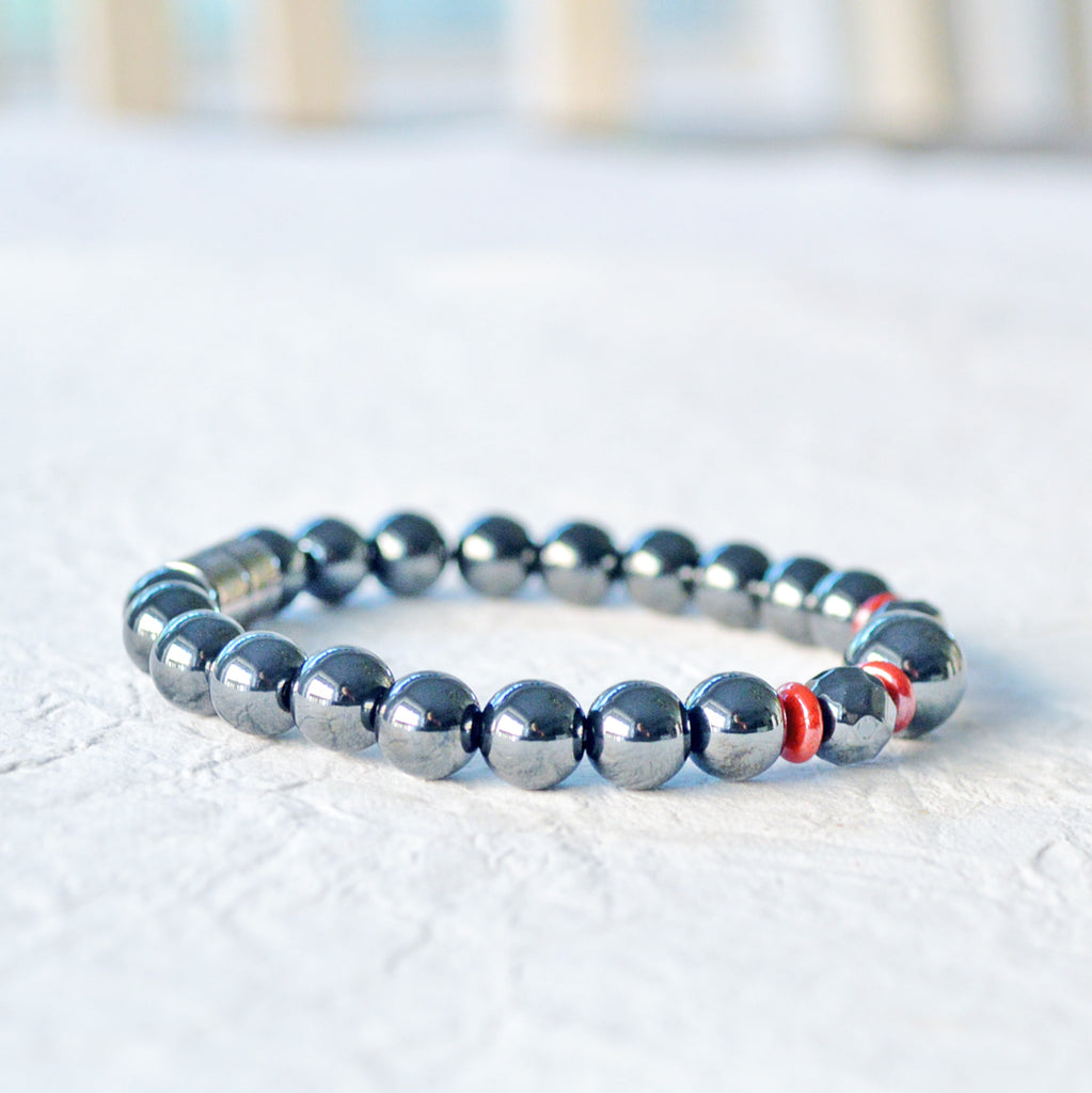 Magnetic bracelet handcrafted with powerful black hematite magnetic beads and accented with red czech glass beads. Bracelet secured with a strong magnetic clasp.