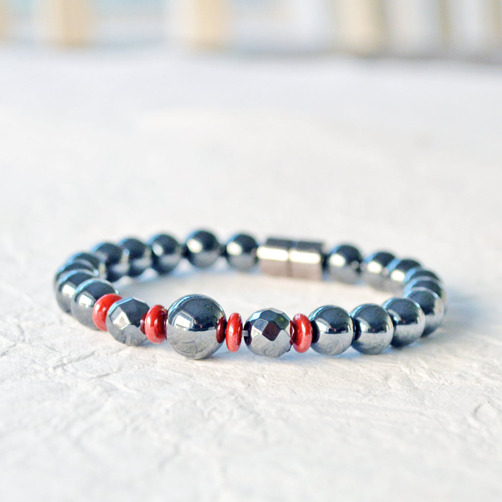 Magnetic bracelet handcrafted with powerful black hematite magnetic beads and accented with red czech glass beads. Bracelet secured with a strong magnetic clasp.