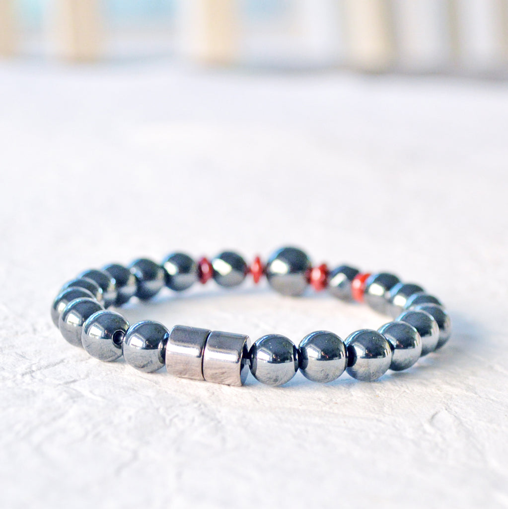 Magnetic bracelet handcrafted with powerful black hematite magnetic beads and accented with red czech glass beads. Bracelet secured with a strong magnetic clasp.