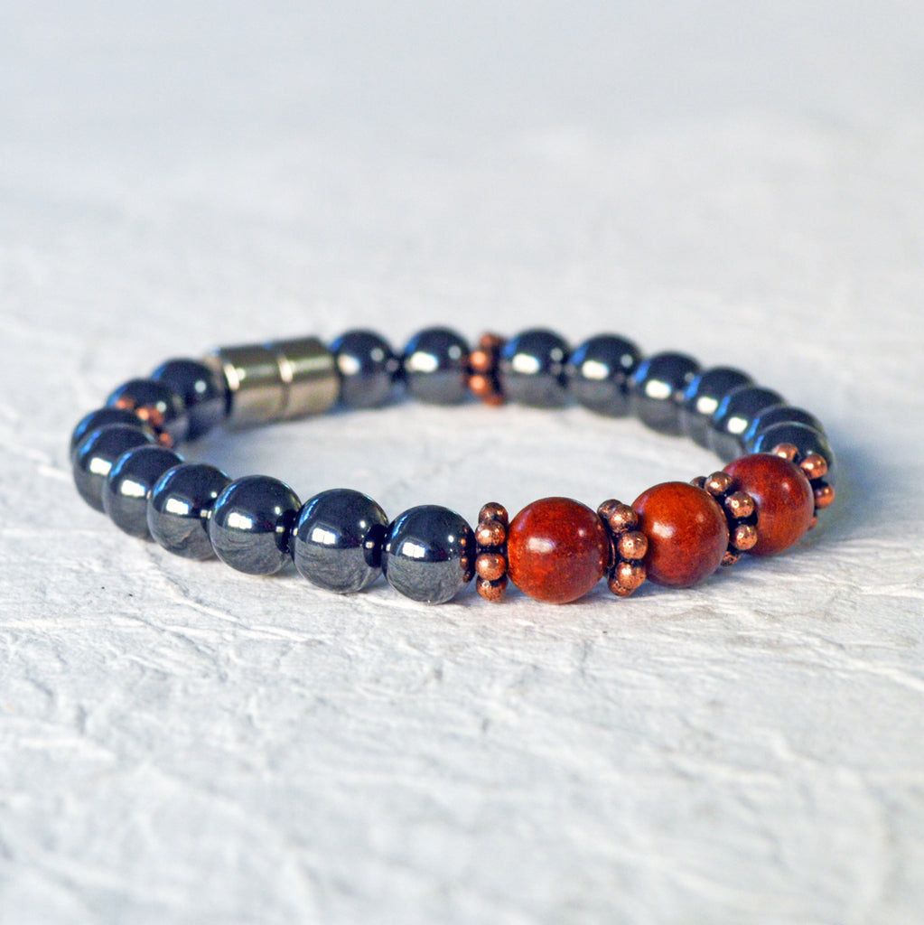 Hematite magnetic bracelet handcrafted with black high power magnetic beads. Raja Kayu wood beads are placed in the center surrounded by antique copper spacer beads.