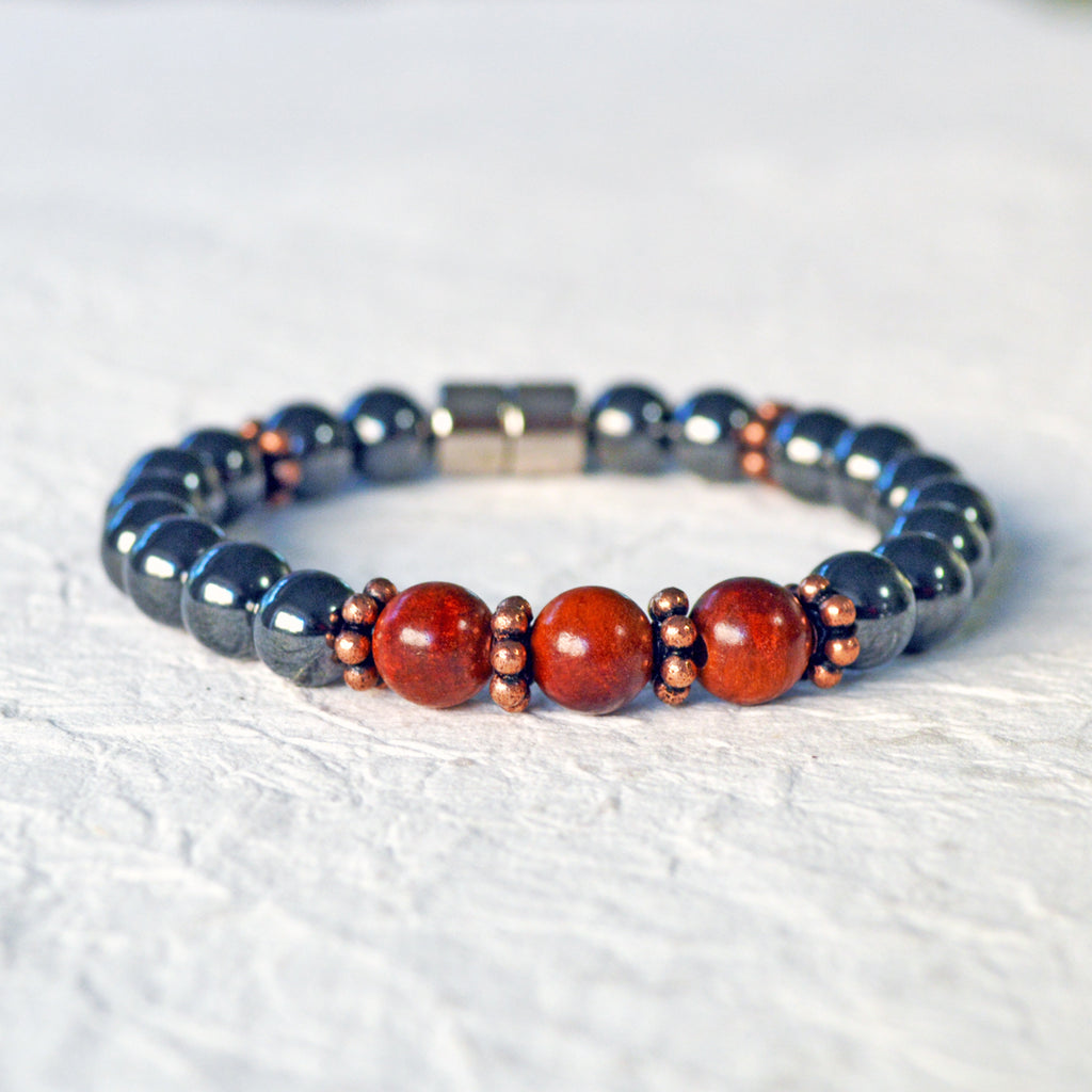 Hematite magnetic bracelet handcrafted with black high power magnetic beads. Raja Kayu wood beads are placed in the center surrounded by antique copper spacer beads.