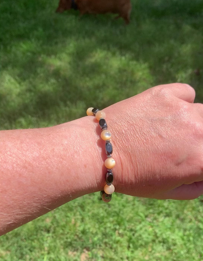 Magnetic bracelet handcrafted with black high power magnetic hematite beads, mother of pearl beads, and sterling silver spacer beads. Secured with a strong and easy-to-use magnetic clasp.